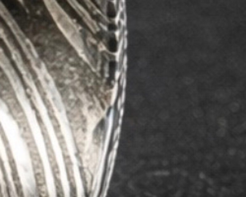 Close detail of the black damascus band, the etched layers reading pale against near black.