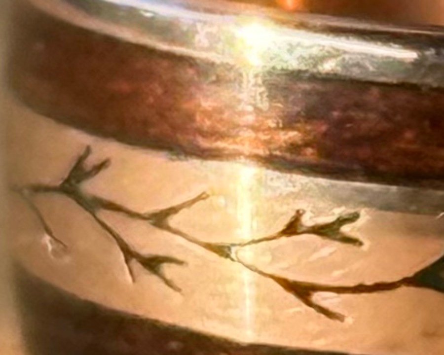 Close detail of the Koa wood inlay, the dark figured grain against the gold.